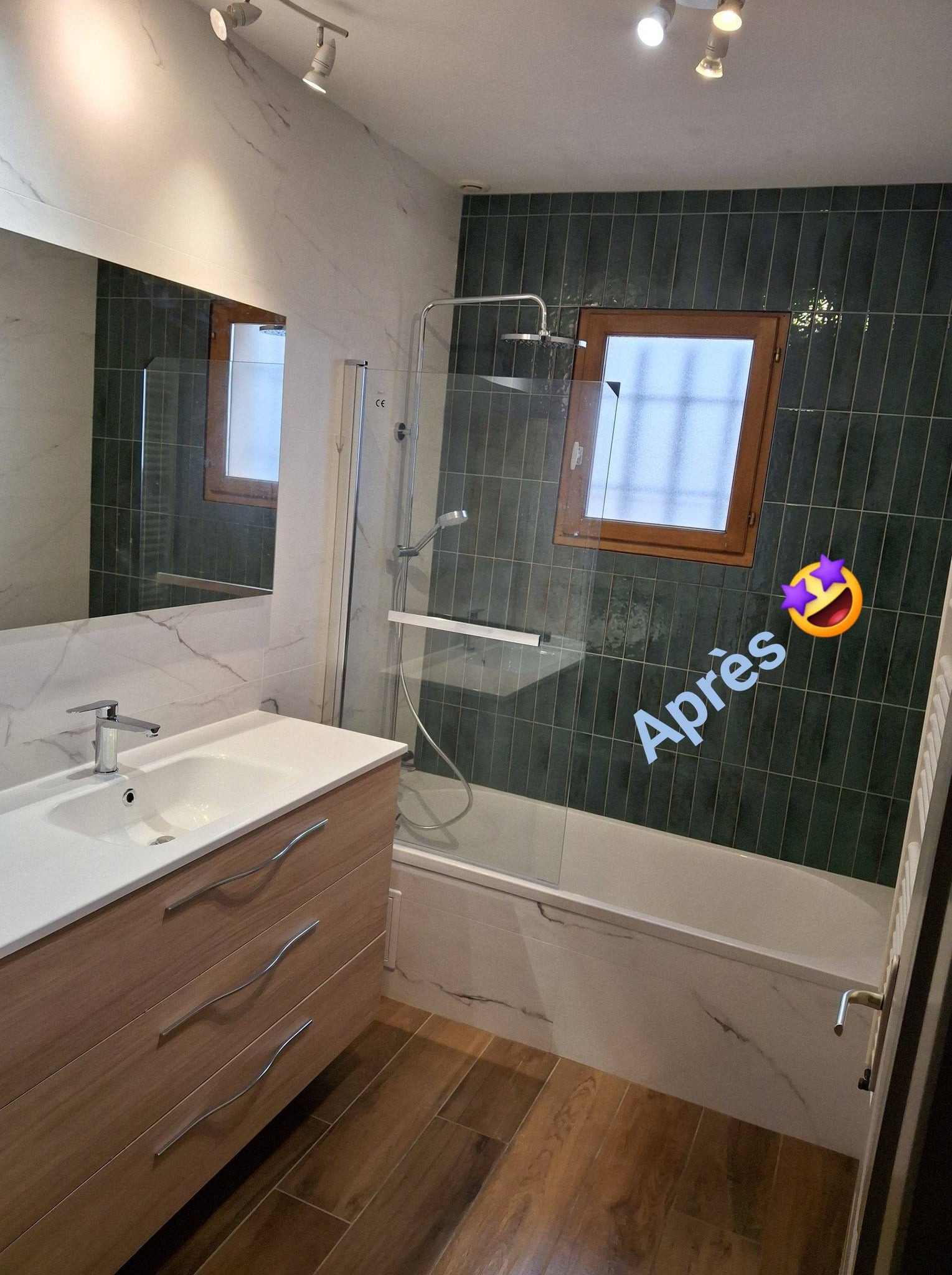 Salle de bain rénovée : carrelage vert, meuble vasque bois et baignoire, avec le texte Après et un emoji.